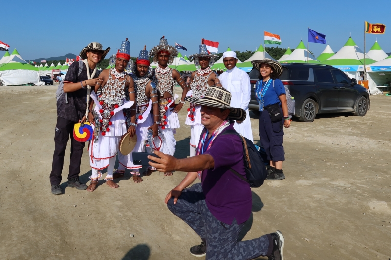 Sri Lankan scouts dressed in ves natuma, the traditional dance costume of their country, on the afternoon of Aug. 5 take a photo with visitors and scouts from other countries at the 25th World Scout Jamboree in Saemangeum, an estuarine tidal flat in Buan-gun County, Jeollabuk-do Province.