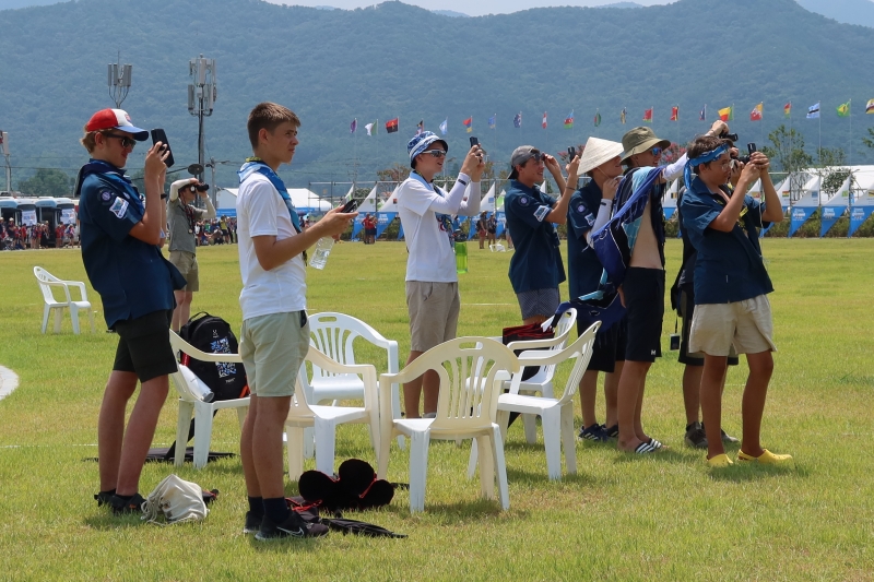 Scouts on the afternoon of Aug. 6 snap photos of the air show by the Black Eagles, the aerobatics team of the Republic of Korea Air Force, at the 25th World Scout Jamboree in Saemangeum. They expressedawe at the spectacular aerobatic maneuvers while watching,with quite a few scouts saying, 