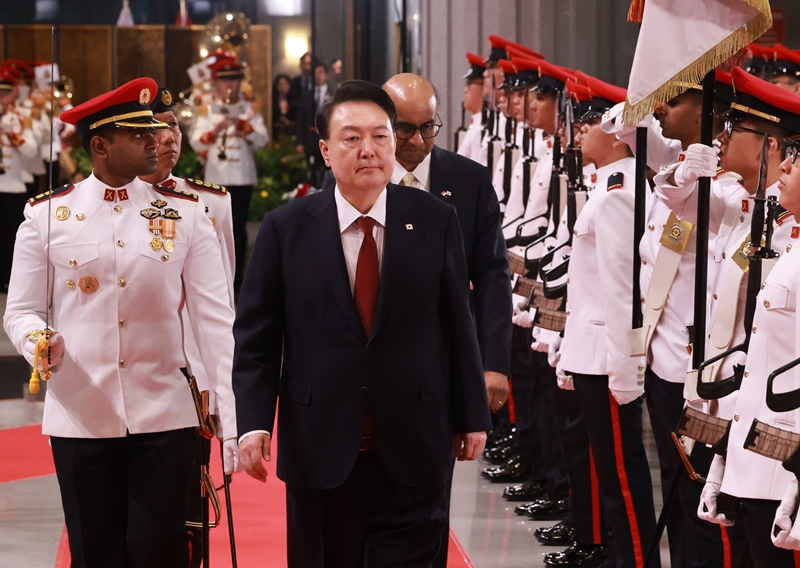 President Yoon Suk Yeol (right) on Oct. 8 inspects an honor guard at his official welcoming ceremony with Singaporean President Tharman Shanmugaratnam at the Parliament House of Singapore. (Yonhap News)  