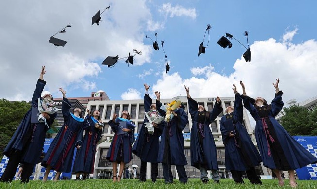 Graduating students throw caps into air