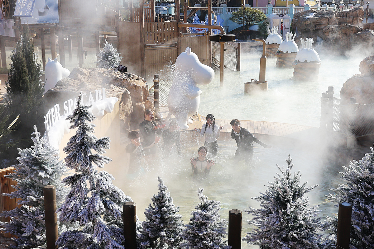 Models on the morning of Dec. 12 enjoy a open-air bath surrounded by cypress trees in a Finnish cylindrical sauna at the water park Caribbean Bay in Yongin, Gyeonggi-do Province.