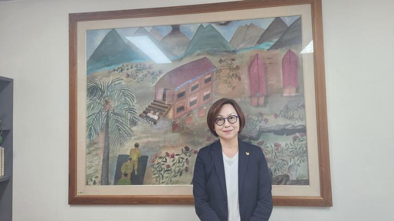 Lee Na-Young, chair of the board of the Korean Council for Justice and Remembrance for the Issues of Military Sexual Slavery by Japan, on July 24 takes a photo in front of a drawing by victim Kang Duk-kyung.  